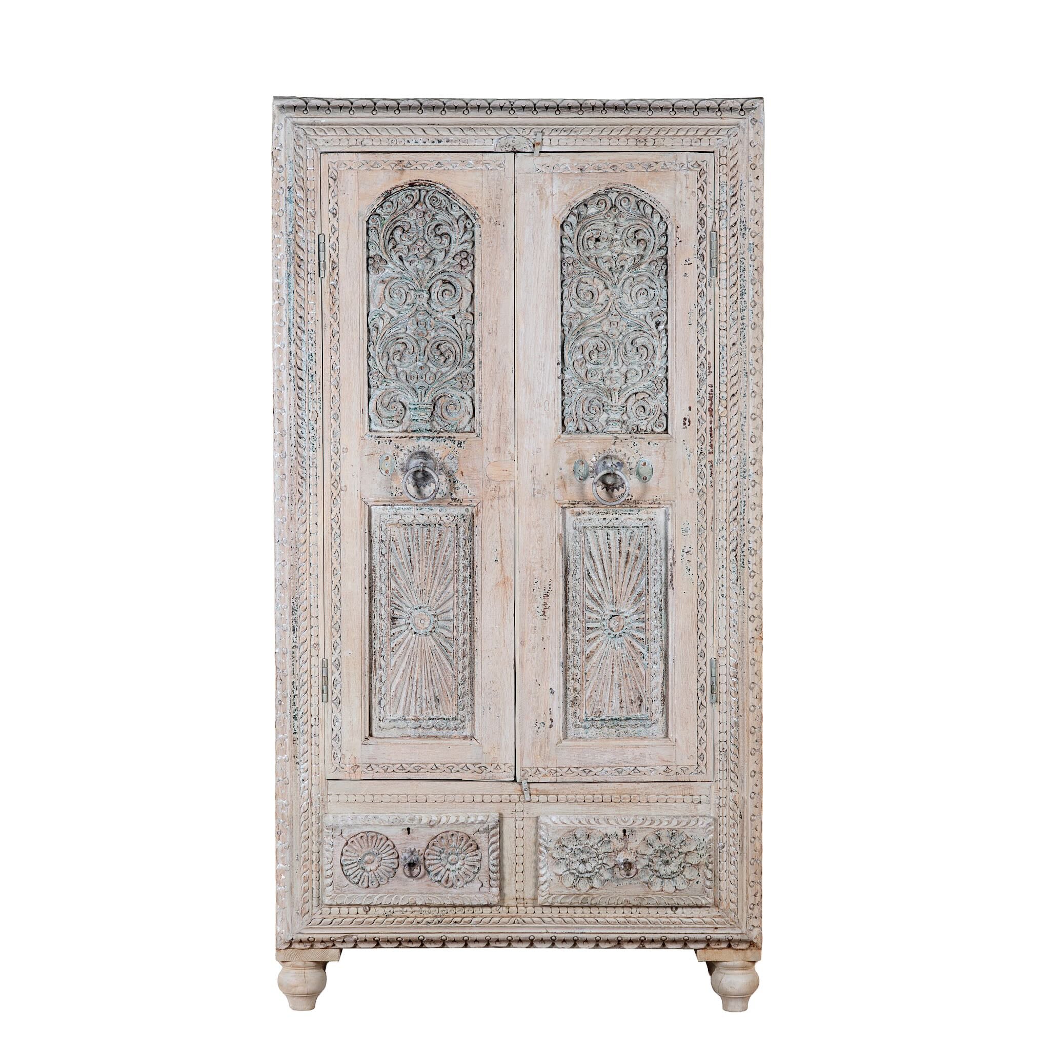 White background image of a Kyra antique reclaimed teak wood wardrobe with intricate Indian hand carvings, double doors, and vintage distressed finish.