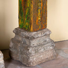 Close up of the stone base of an antique pair of carved wooden house pillars with original stone bases, weathered multicolour finish, 210 cm high, vintage home decor and boho chic living room accents.