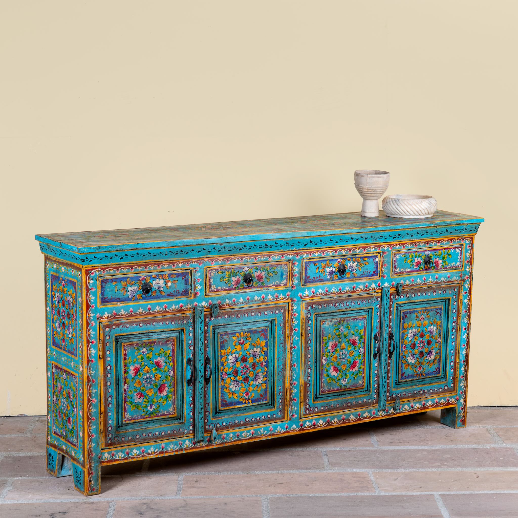 Side angle image of a Laksh hand painted reclaimed wood sideboard in boho style with distressed vintage finish and traditional Indian floral artwork.