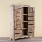 Side angle image with open doors of a Lakshya bleached mango wood cabinet with original hand carved Indian door panels and iron fittings 167cm