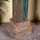 Close up image of the stone base of an antique pair of carved wooden house pillars with original stone bases, weathered multicolour finish, 210 cm high, vintage home decor and boho chic living room accents.