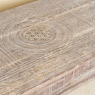 Close-up of a teak wood coffee table with antique carved door top, also ideal as an entryway table vintage statement piece.