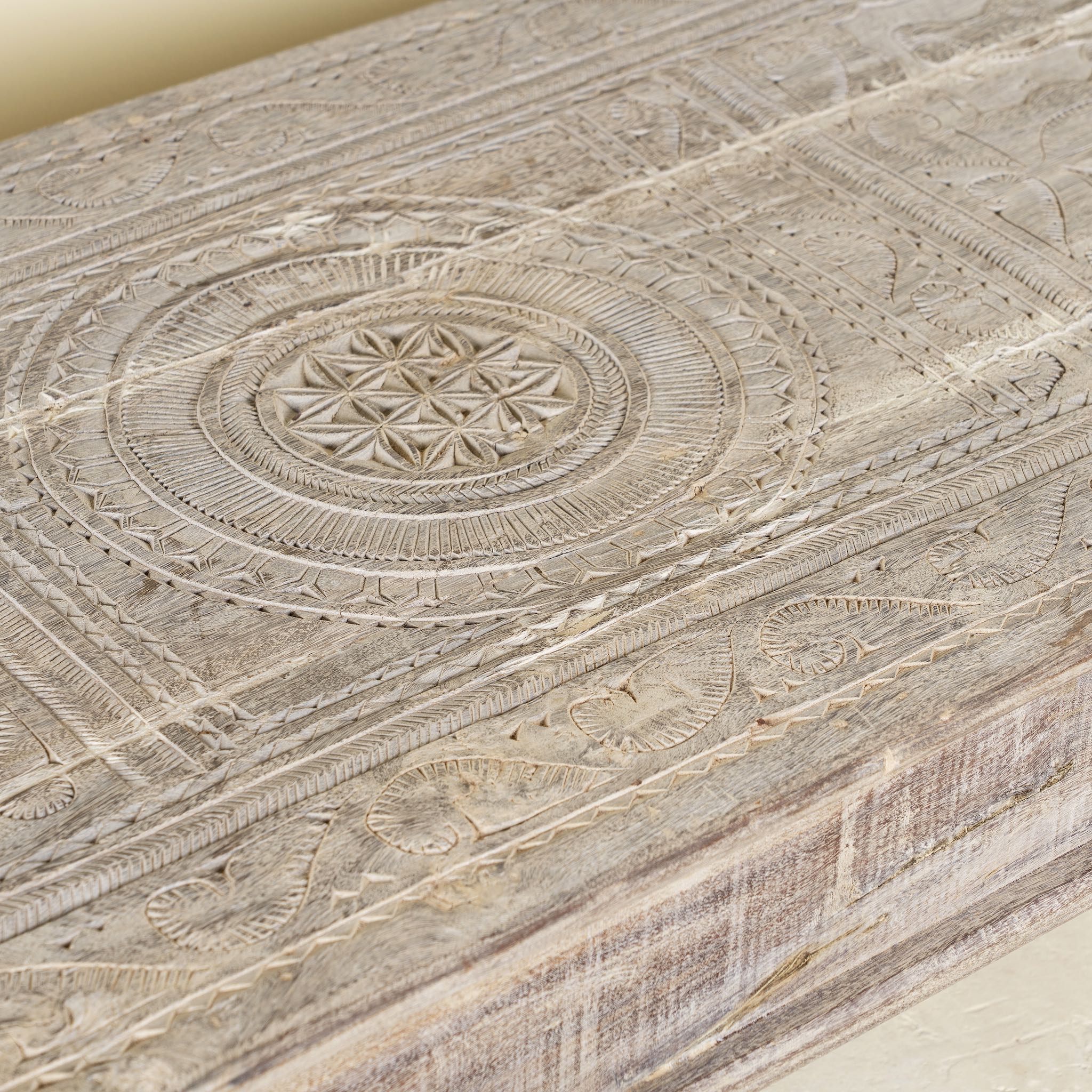 Close-up of a teak wood coffee table with antique carved door top, also ideal as an entryway table vintage statement piece.