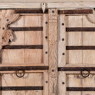 Close up image of a reclaimed teak furniture sideboard with antique Indian doors, old door cabinet with hand-carved details and iron accents, 220 × 45 × 110 cm.