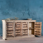 Open door view of a reclaimed teak furniture sideboard with antique Indian doors, old door cabinet with hand-carved details and iron accents, 220 × 45 × 110 cm.