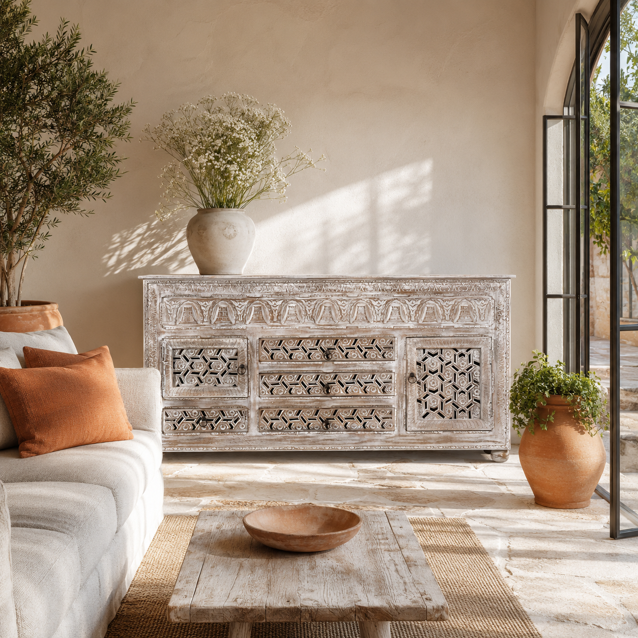 Lifestyle image of a hand-carved wooden sideboard made from solid mango wood with drawers and compartments; unique furniture piece in Mediterranean style, 180 × 100 × 40 cm.