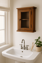 lifestyle image of a Leo small rustic bathroom wall cabinet made of reclaimed teak wood with glass door and shelves; bathroom furniture in vintage style, 40 × 15 × 63 cm.