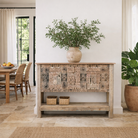 Lifestyle image of a reclaimed teak console table with hand-carved antique elements and rustic finish, 140 × 38 × 93 cm.