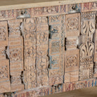 Close up image of a reclaimed teak console table with hand-carved antique elements and rustic finish, 140 × 38 × 93 cm.