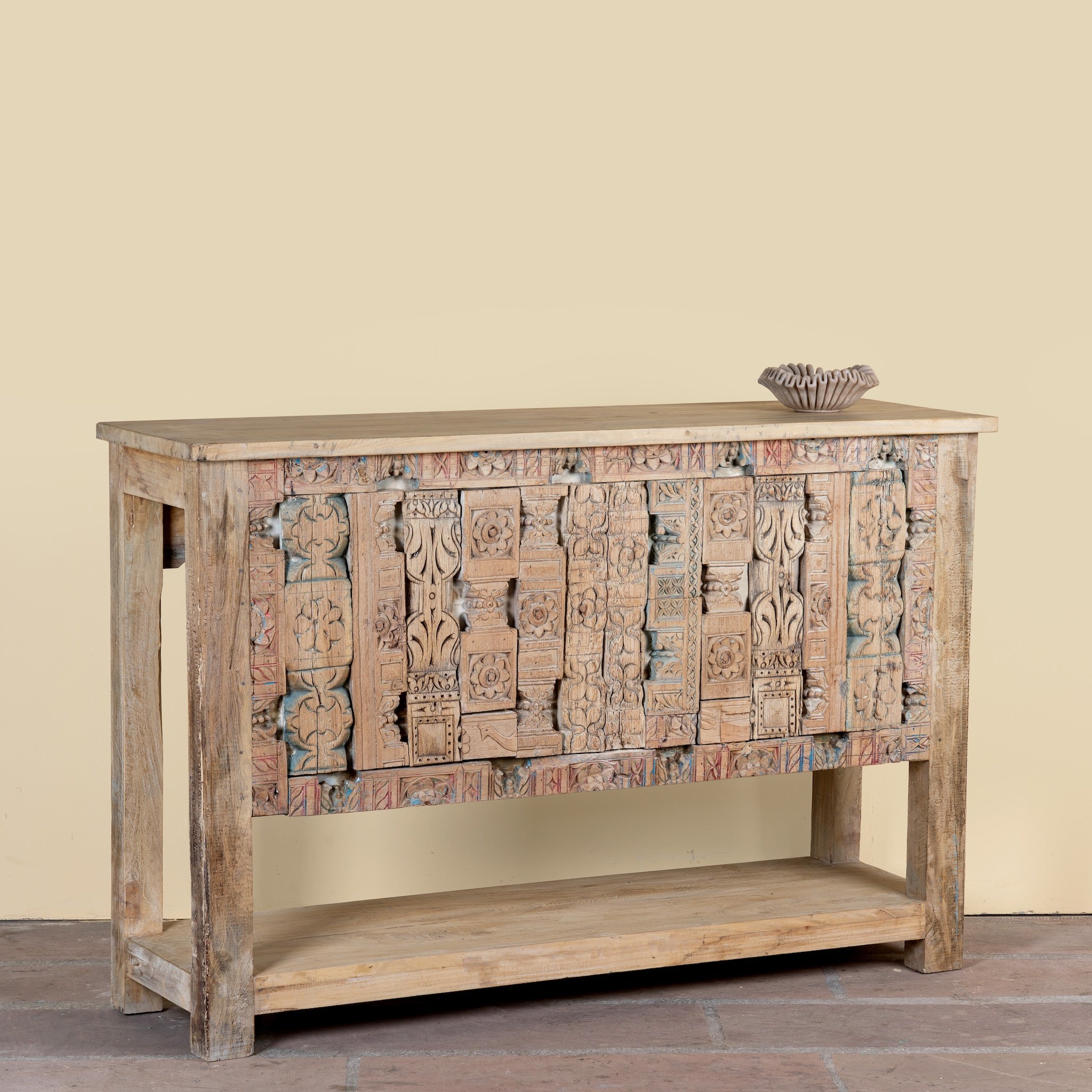 Side angle image of a reclaimed teak console table with hand-carved antique elements and rustic finish, 140 × 38 × 93 cm.