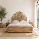 Lifestyle image of a hand-carved wooden bed frame in mango wood featuring an intricate lotus flower design – Lotus bed 180x200 cm by Om Home & Garden