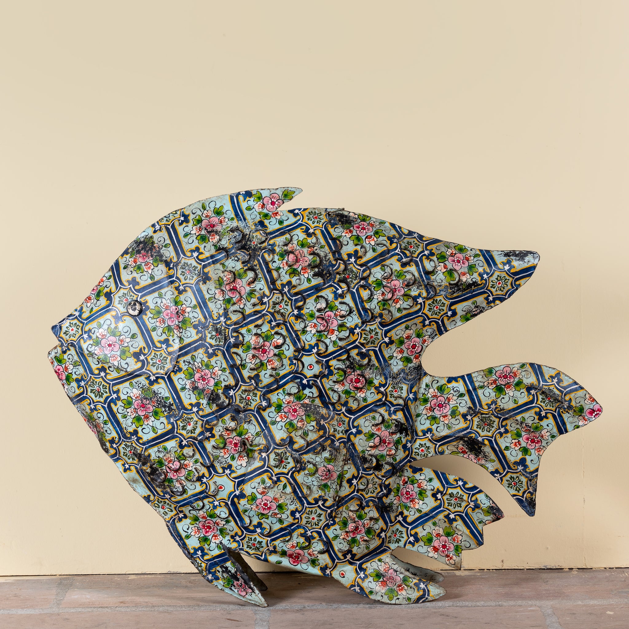 Maah hand painted freestanding metal fish sculpture featuring Delft-inspired blue tile patterns with pink floral motifs, handcrafted decorative home accessory, 107x15x80cm.