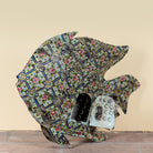 Side angle image of a Maah hand painted freestanding metal fish sculpture featuring Delft-inspired blue tile patterns with pink floral motifs, handcrafted decorative home accessory, 107x15x80cm.