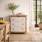 Lifestyle image of a mango wood carved chest of drawers with whitewashed floral engraved fronts, 80 × 40 × 90 cm.