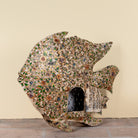 Side angle image of a Malini hand painted freestanding metal fish sculpture with intricate floral artwork in soft green, cream and earthy tones, handcrafted decorative home accessory, 107x15x80cm.