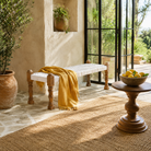 Lifestyle image of a Mamit wooden bench with handwoven cotton seating and reclaimed wood frame, 120cm