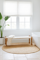 Lifestyle imagination of a low mango wood bench with handwoven cotton seat and recycled wood frame; Indian daybed-style, 120 × 45 × 20 cm.
