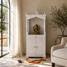 Lifestyle image of a mango wood house temple in whitewashed finish with carved floral doors and traditional arched canopy—an elegant example of hand-carved Mandirs and Indian home temples.