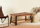Side angle image of a Rustic driftwood coffee table made from reclaimed wood with sandblasted finish; sustainable furniture, 100 × 50 × 45 cm.