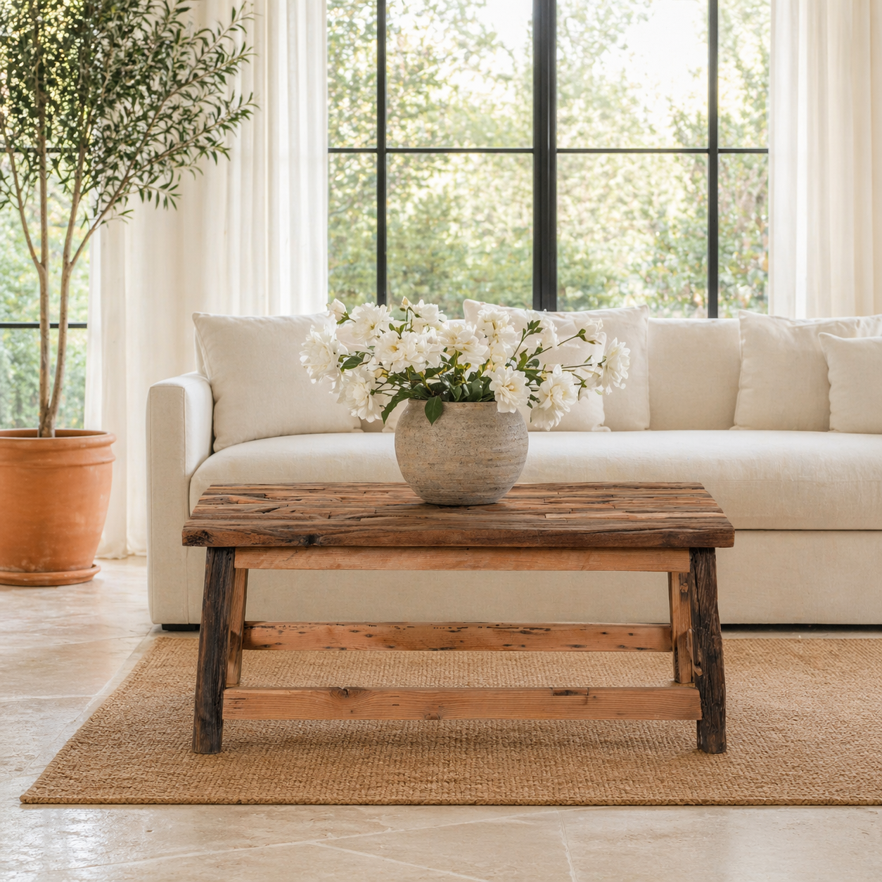 Lifestyle image of a rustic driftwood coffee table made from reclaimed wood with sandblasted finish; sustainable furniture, 100 × 50 × 45 cm.