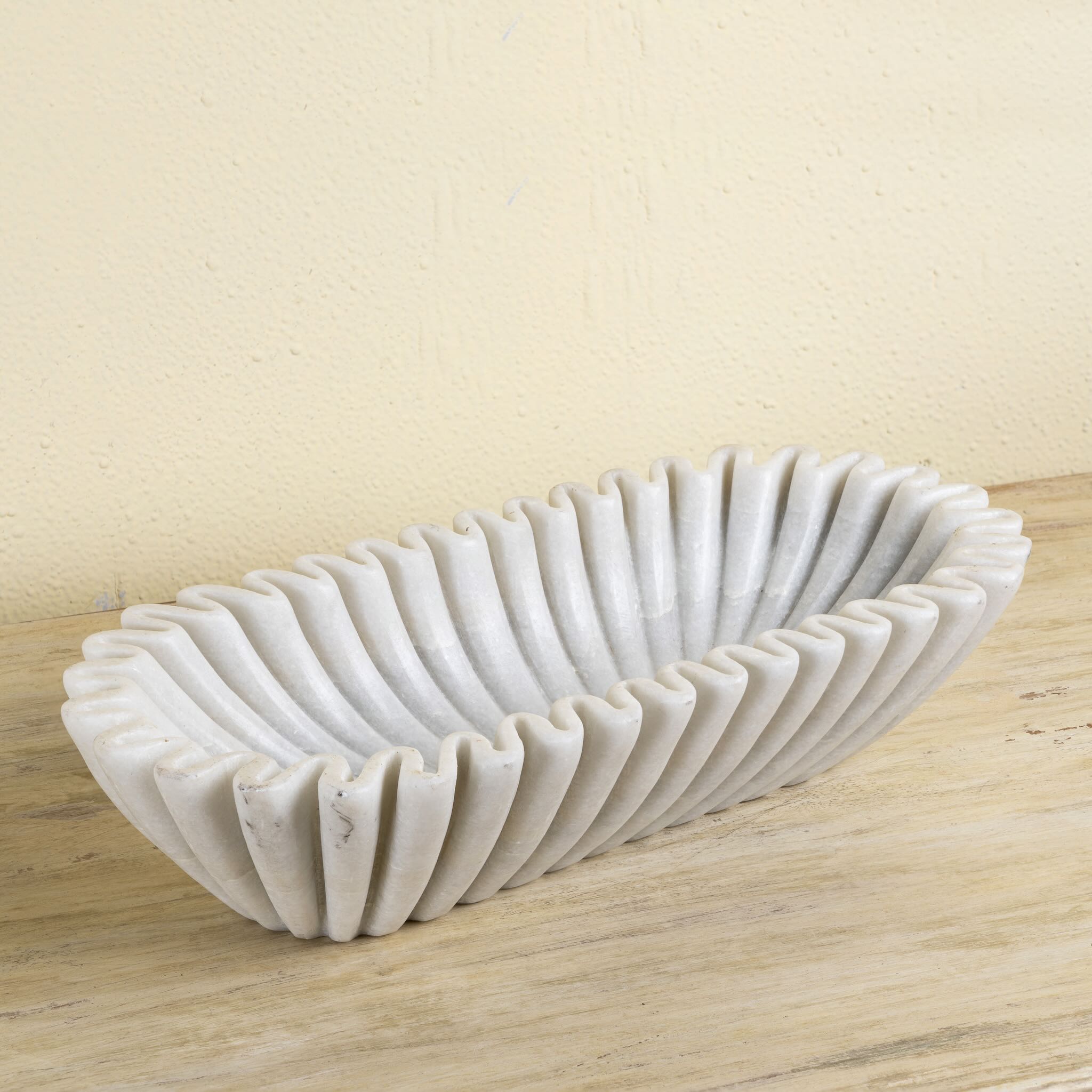 Elongated hand-carved white marble bowl with folded pleated edges – Indian decorative marble accessory.