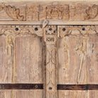 Close up image of a rustic solid wood wardrobe featuring vintage reclaimed door panels with iron accents and ring pull handles.