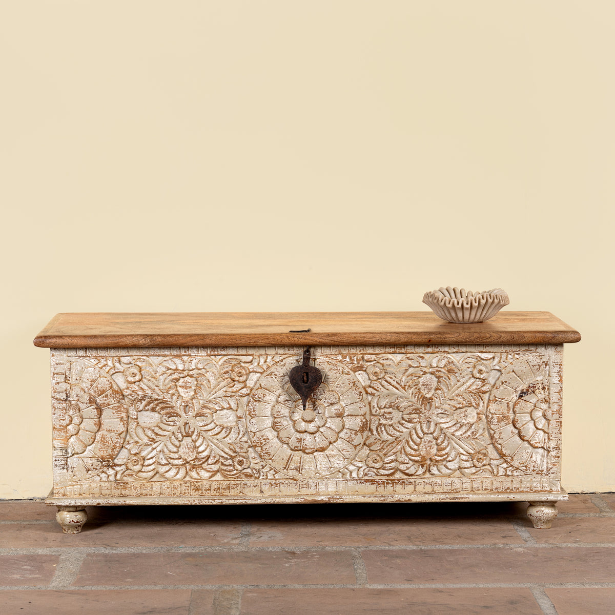 Image of a Hand-carved mango wood chest box with floral motifs, whitewashed finish, and iron handles – vintage home accessory for rustic and elegant interiors.
