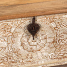 Close up image of a hand-carved mango wood chest box with floral motifs, whitewashed finish, and iron handles – vintage home accessory for rustic and elegant interiors.

