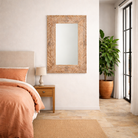 Lifestyle image of a of a carved mango wood mirror Anumati with floral motifs and distressed finish. A handcrafted Indian furniture piece perfect for vintage home decor and artisanal interiors.