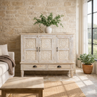 Lifestyle imagination of a whitewashed hand carved wooden sideboard made from solid mango wood with floral patterns, 3 doors and 2 drawers; artisanal mango wood furniture, 120 × 100 × 40 cm.