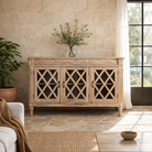 Lifestyle imagination of a rustic sideboard made of Mango wood with hand-carved details and glass panelled doors featuring a diamond lattice design.