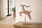 Lifestyle image of a handcrafted wooden deer sculpture Rijul on an iron stand with a whitewashed finish. A vintage home accessory and unique Indian decoration ideal for vintage home decor on consoles or shelves.