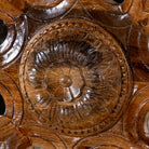 Close up image of a round mango wood mirror Ojis with hand-carved floral frame. A unique wall decor piece combining traditional Indian craftsmanship and organic design.