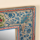 Close up image of a Mishika hand-painted reclaimed wood wall mirror with intricate blue floral artwork and traditional Indian decorative motifs, 90x90x5cm.
