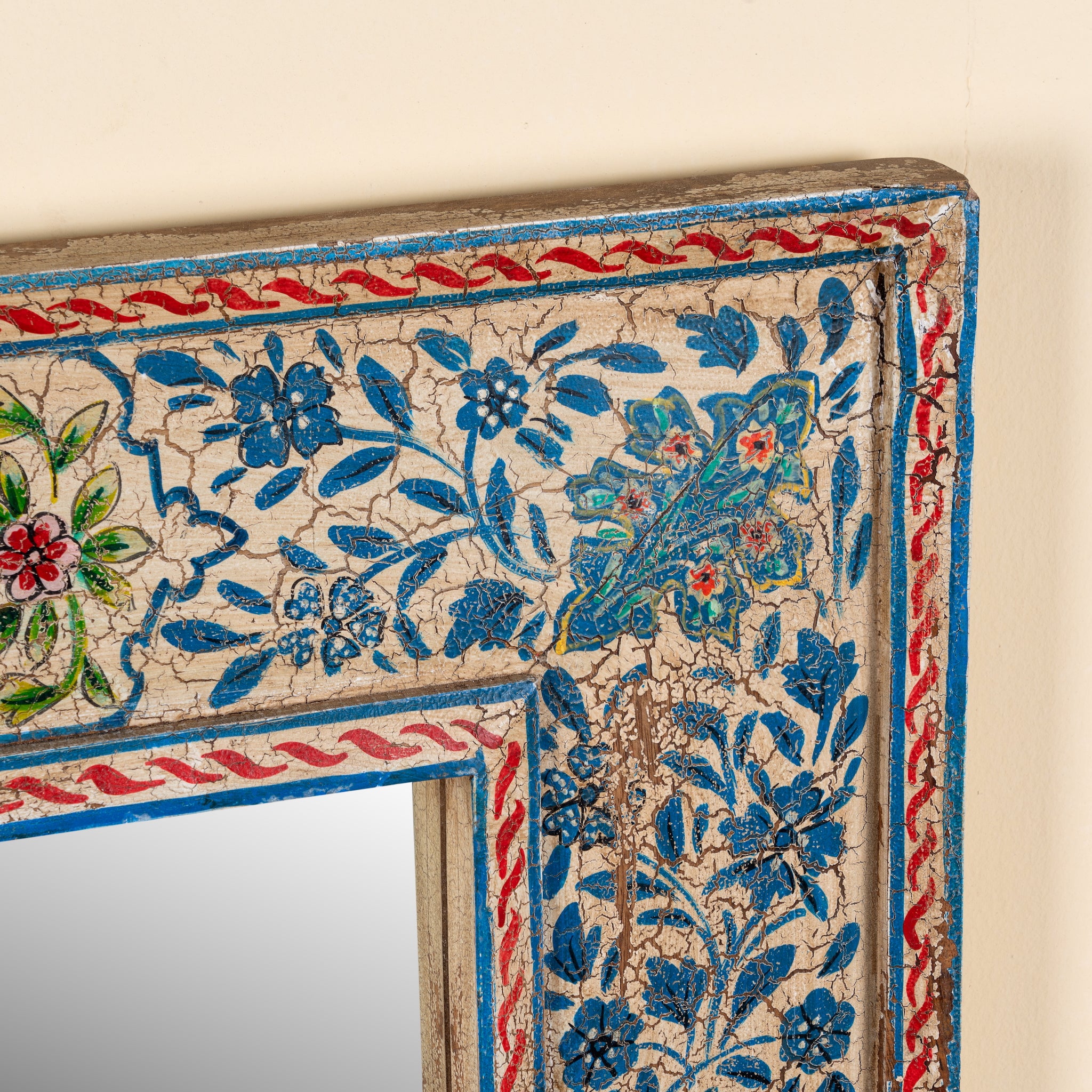 Close up image of a Mishika hand-painted reclaimed wood wall mirror with intricate blue floral artwork and traditional Indian decorative motifs, 90x90x5cm.
