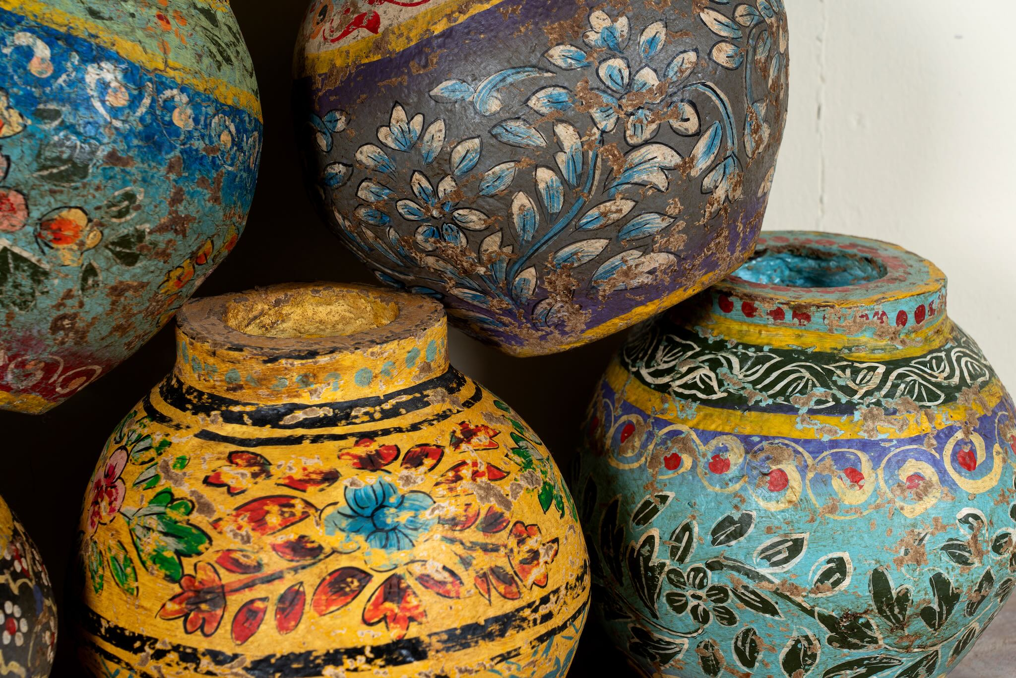 Mixed designs of hand-painted papier-mâché vases from India with floral folk-art designs in vibrant mixed colours. Unique Indian decor and decorative art objects handcrafted using traditional methods.