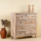 Side angle image of a carved mango wood cabinet with drawers and one door, made from reclaimed teak, 100 × 40 × 100 cm.