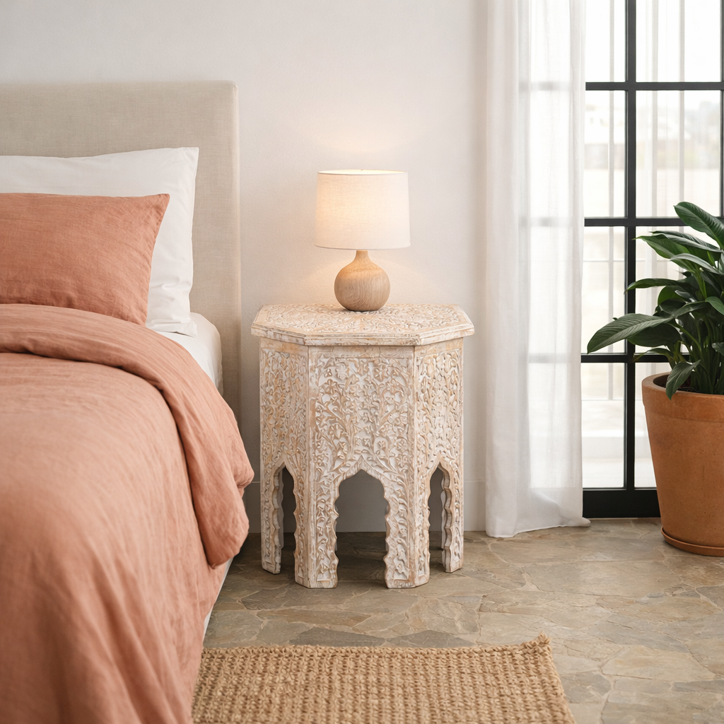 Lifestyle image of a hand carved white washed vintage coffee table with floral motif.