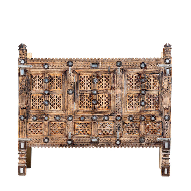 White background image of an antique Indian treasure chest in solid teak with sandblasted finish, hand-carved details, and iron accents. Vintage home accessory for eclectic Indian decor, 127 × 110 × 47 cm.