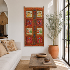Lifestyle image of a hand-painted Indian antique teak wood door with mythological and folk motifs, vibrant orange frame, vintage wall panels for spiritual and artistic home decor.