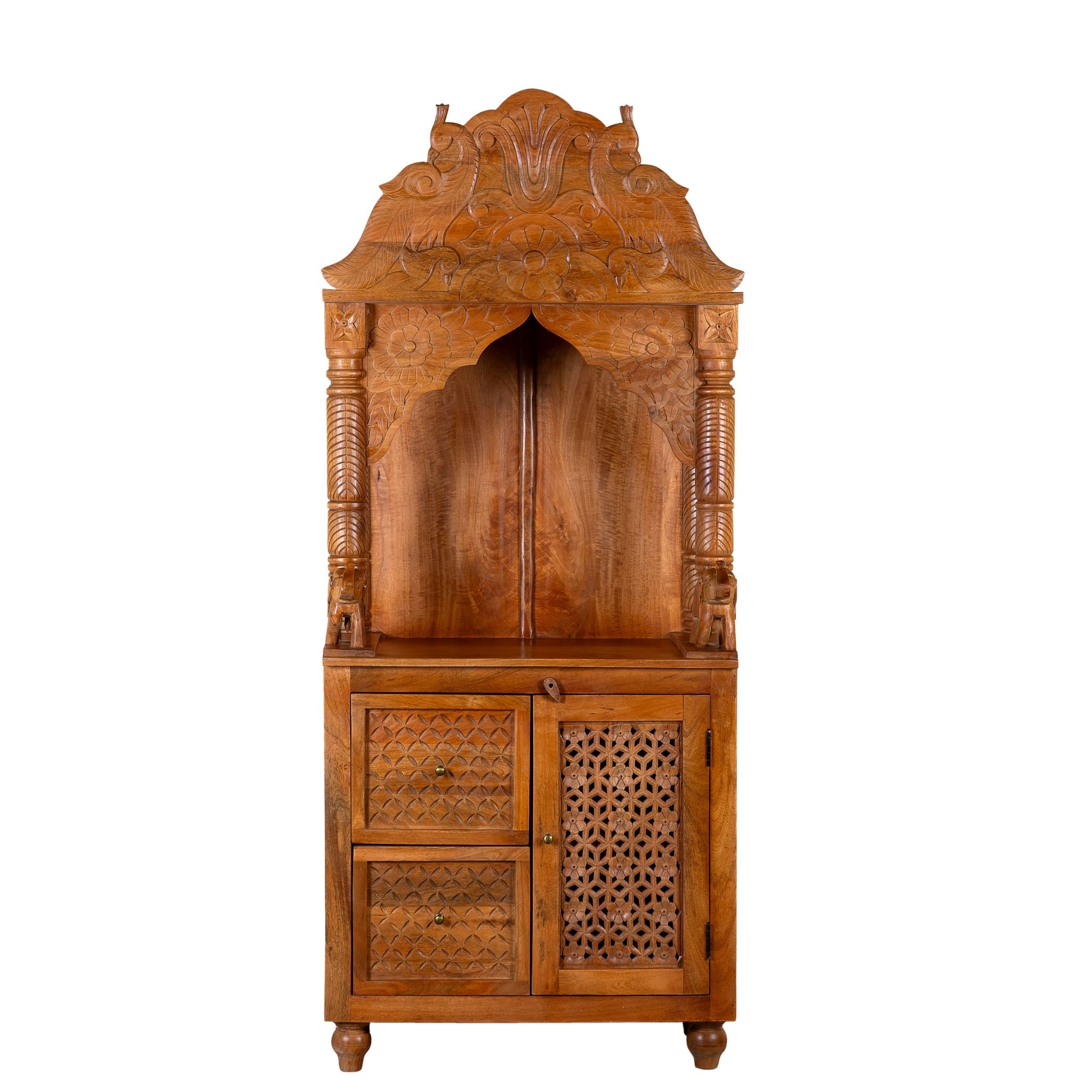 White background image of a Moksha hand carved mango wood mandir with decorative Indian carvings, drawers, and cabinet storage.