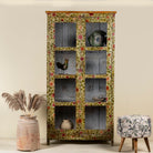 Hand-painted reclaimed wood cabinet with glass doors and floral motifs – sustainable and artistic furniture for vintage or bohemian interiors.