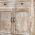 Close up image of a living room furniture sideboard made from hand-carved mango wood, vintage style furniture with sunburst patterns and distressed finish, 180 × 40 × 90 cm.