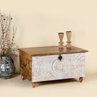 Side angle image of a hand carved mango wood chest box with white washed vintage finish and iron lock, 105x70x55 cm