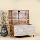 Side angle image with open lid of a hand carved mango wood chest box with white washed vintage finish and iron lock, 105x70x55 cm