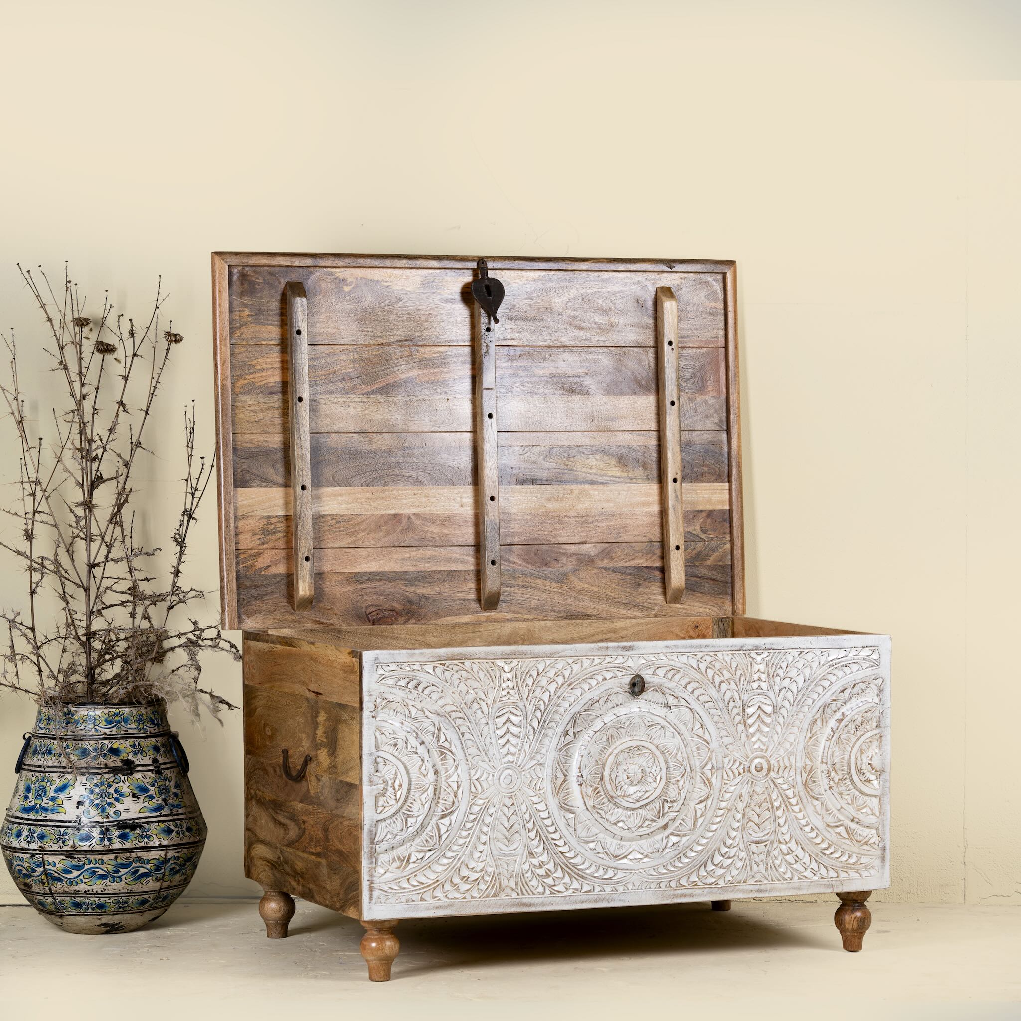 Side angle image with open lid of a hand carved mango wood chest box with white washed vintage finish and iron lock, 105x70x55 cm