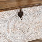 Close up image of a hand carved mango wood chest box with white washed vintage finish and iron lock, 105x70x55 cm