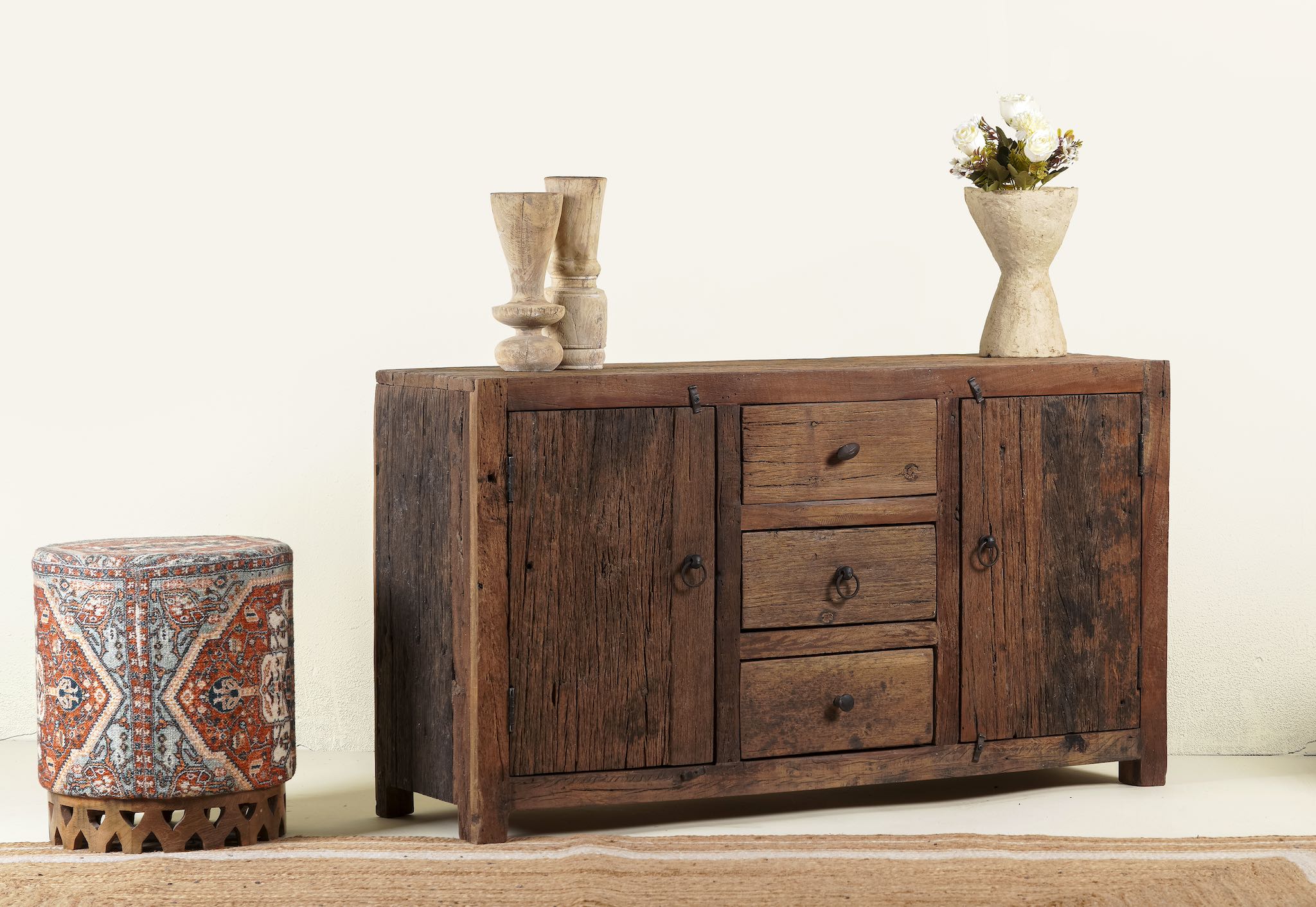 Side angle image of a storage rustic sideboard made of reclaimed wood with 3 drawers and 2 doors.