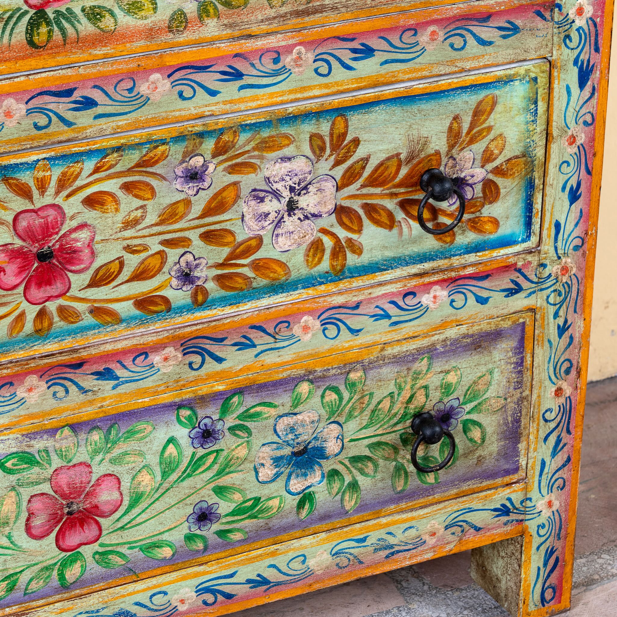 Close up image of a Neel hand painted reclaimed wood chest of drawers with five floral drawers and colourful boho vintage finish.
