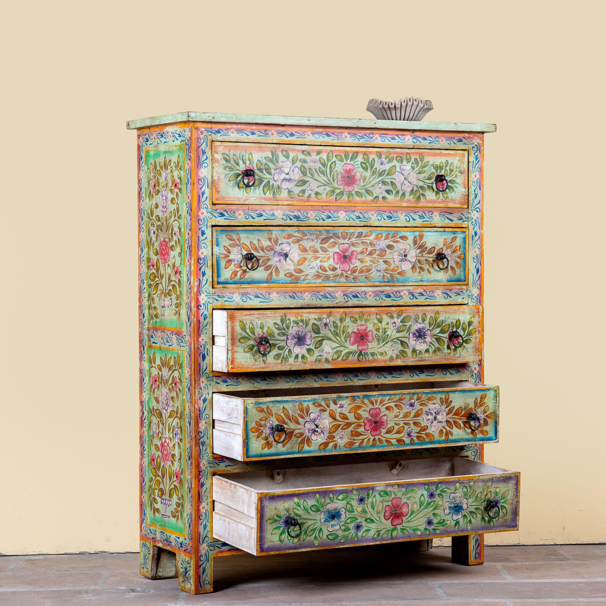 Side angle image with open drawers of a Neel hand painted reclaimed wood chest of drawers with five floral drawers and colourful boho vintage finish.